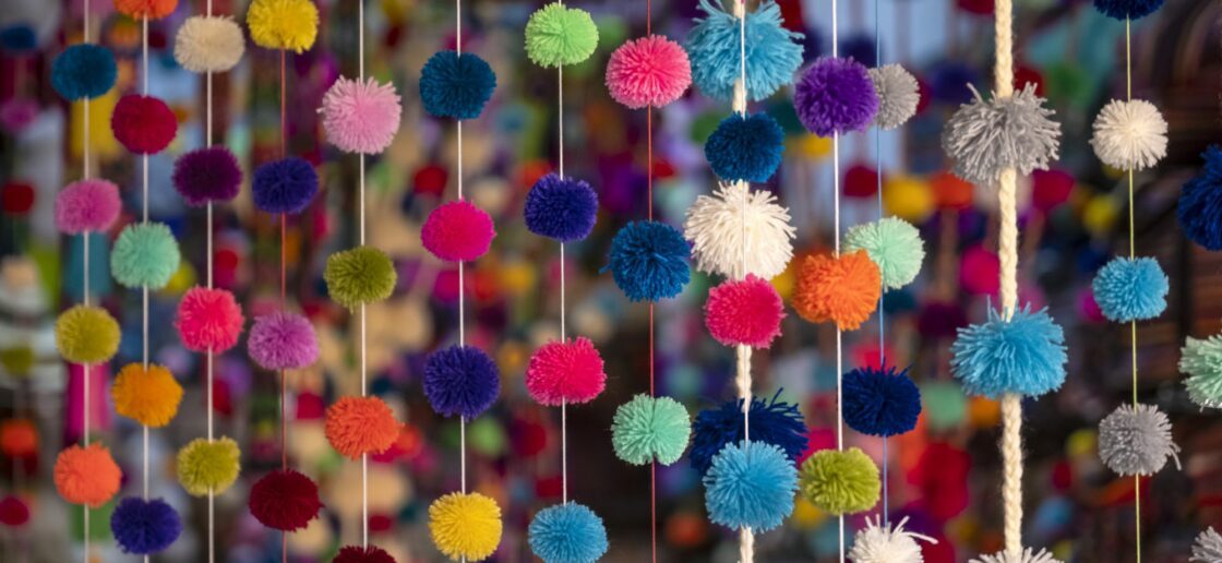 Créez une guirlande de pompons, une des activités de Mardi Gras imaginée par les enfants !
